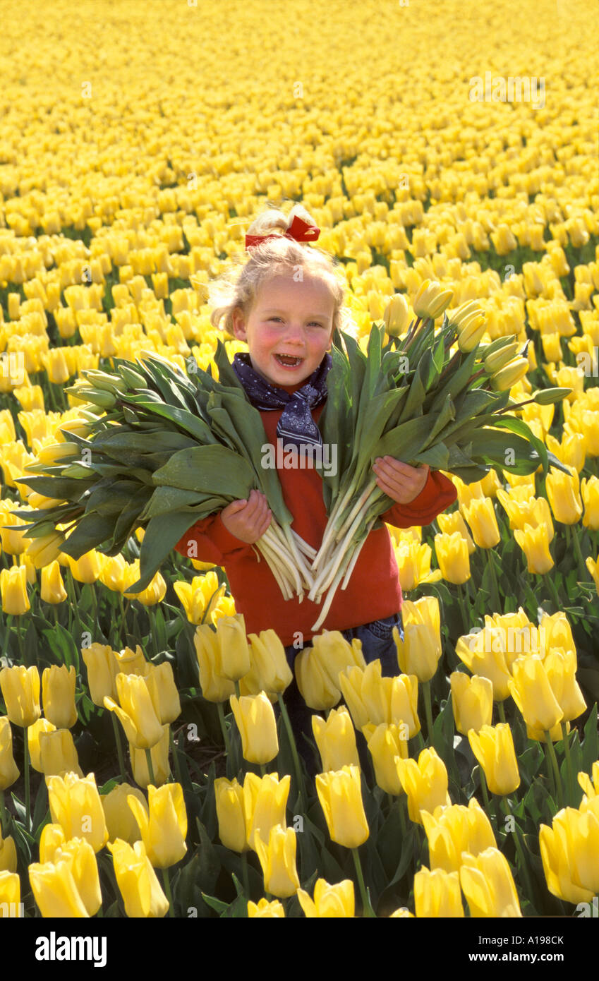 Kleine blonde Mädchen stehen in einem flowerfield Stockfoto