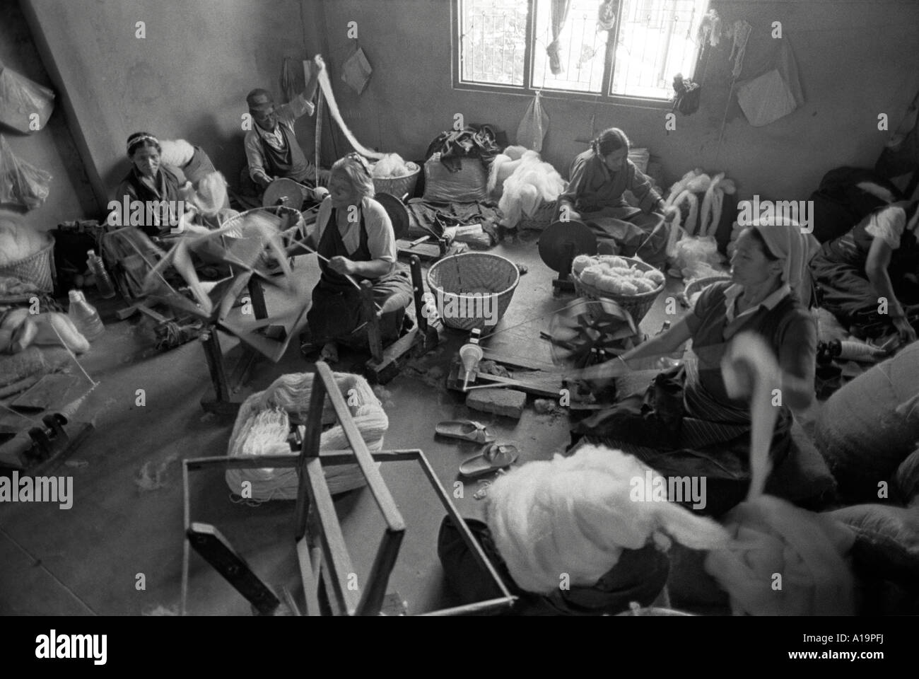 S/W von tibetischen Flüchtlingsfrauen, die Wolle in einer Fabrik wickeln, die traditionelle tibetische Teppiche produziert. Kathmandu, Nepal Stockfoto