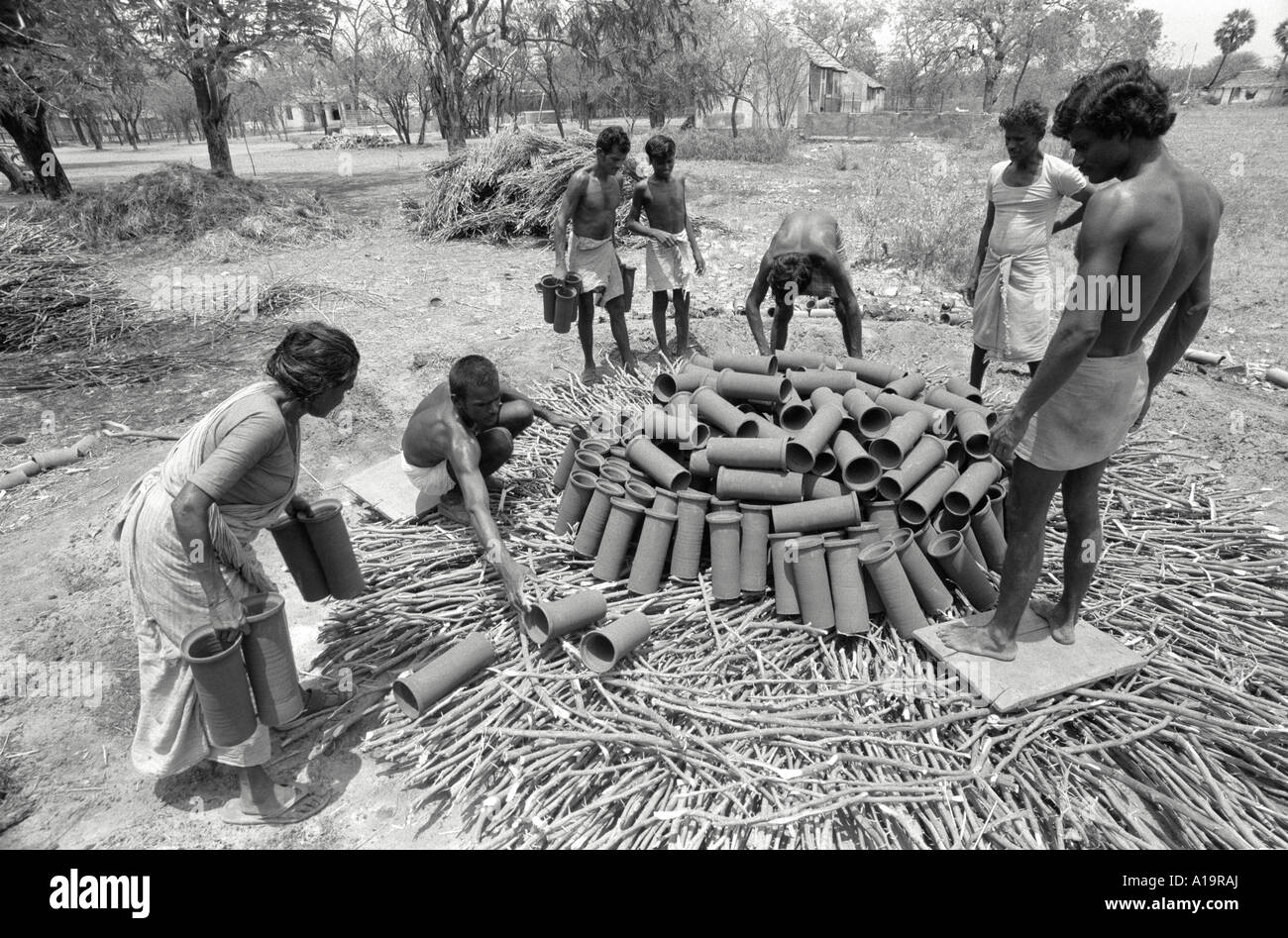 S / W von Töpferarbeitern Laden einer primitiven traditionellen Brennofen mit handgefertigten Tonabflussrohren zum Brennen. Tamil Nadu, Südindien Stockfoto