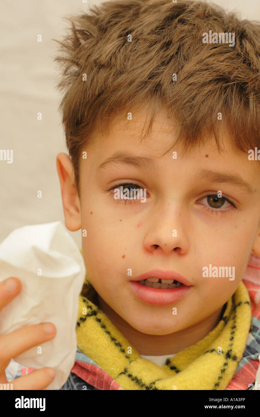 Jungen im Alter von 10 Jahren krank mit kalten Grippe mit Tuch und Schal warm zu halten Stockfoto