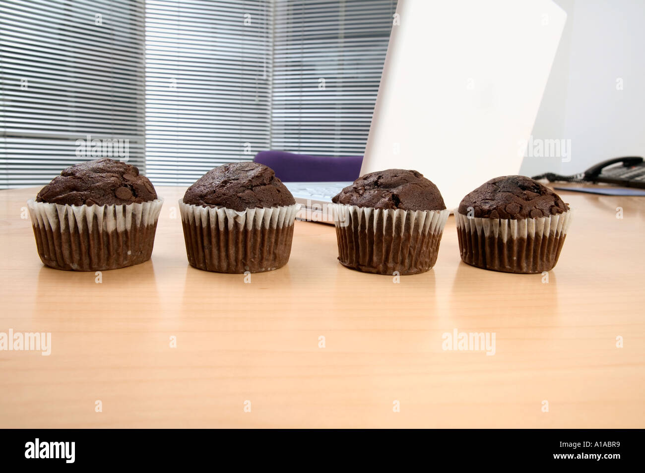 Schokoladen-Muffins auf einem Schreibtisch Stockfoto