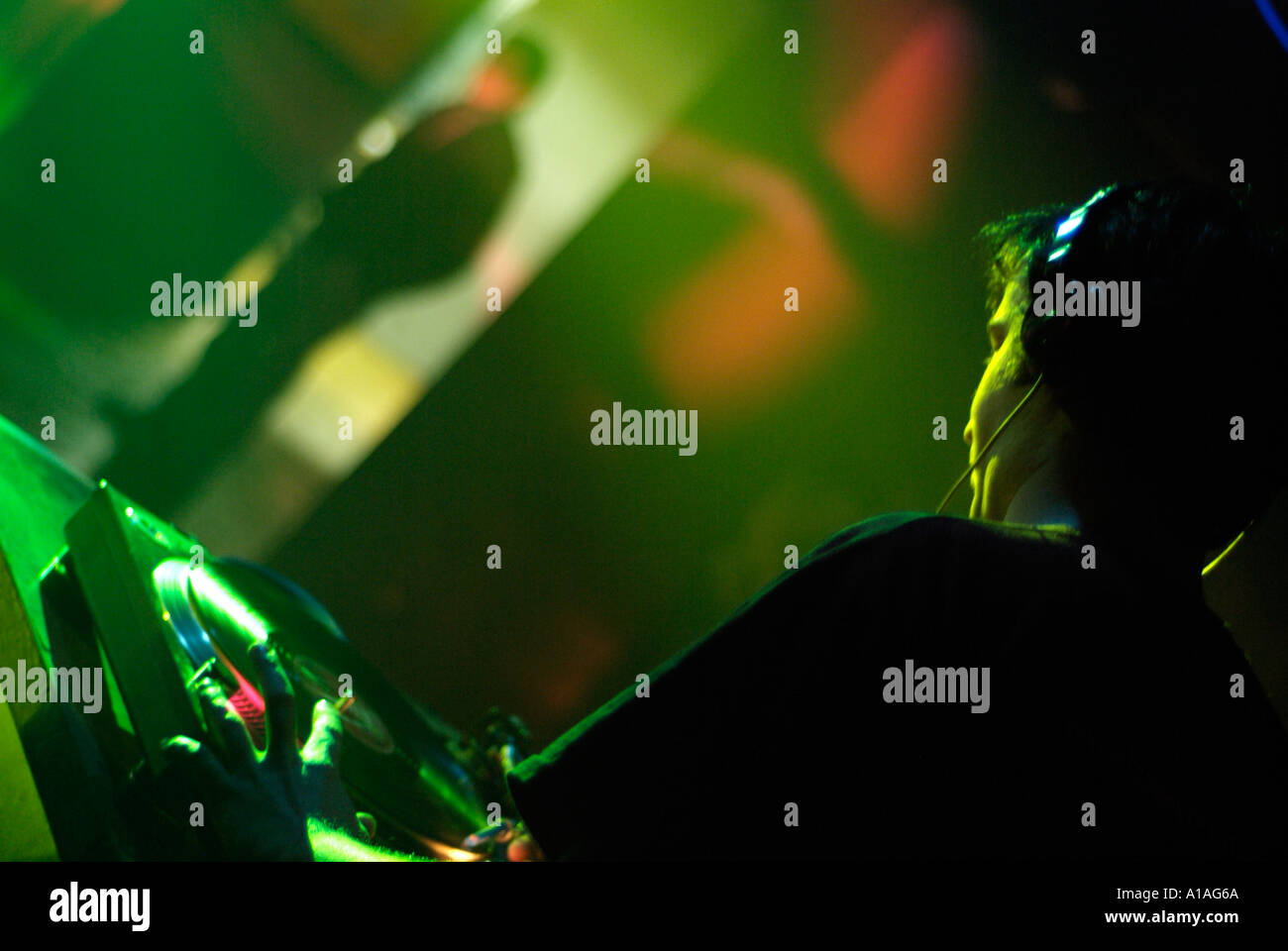 Club-DJ Cutting in einer Spur auf einer Drehscheibe hinter den Decks einer Diskothek Stockfoto
