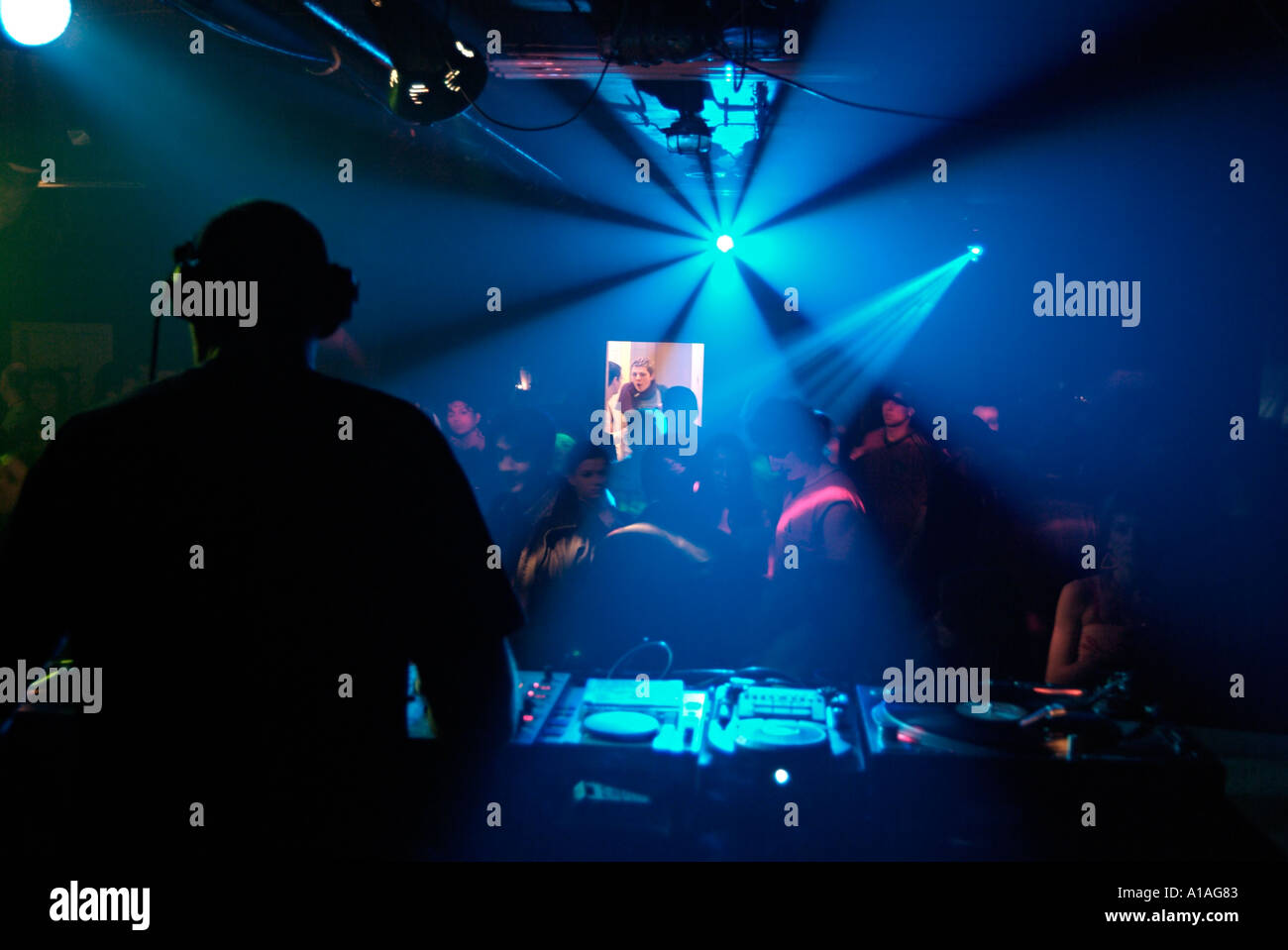 Diskothek DJ spielt einen Satz in einem überfüllten Nachtlokal Stockfoto