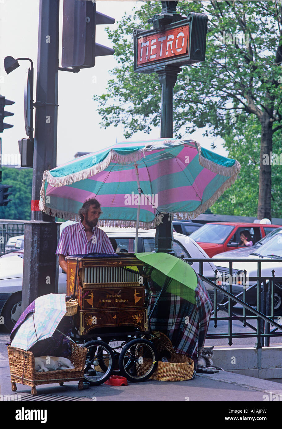 Drehorgelspieler macht Musik mit eine altmodische Orgel außerhalb Paris Mtro station Stockfoto