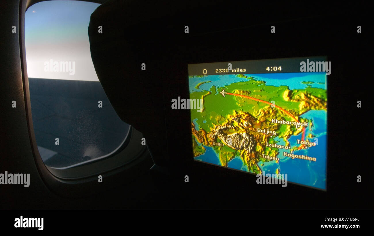 Platz für Monitor zeigt Karte von Eurasien und Flug auf dem Weg von Japan abgedunkelten Kabine mit Fenster und Blick auf die Boeing 747-Flügel Stockfoto