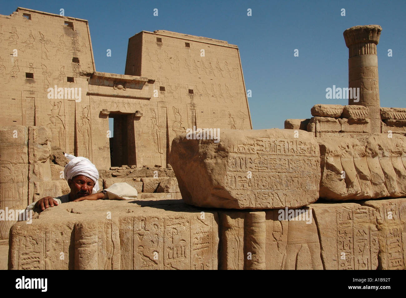 Ägyptischen Mann inmitten der Ruinen der antiken Tempel von Edfu, dem Falkengott Horus geweiht, in ptolemäischer Zeit zwischen 237 und 57 v. Chr. gebaut. Ägypten Stockfoto