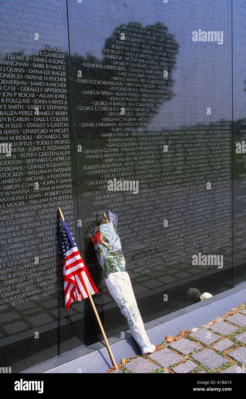 Flagge und Blumen gegen die Liste der Namen auf den Vietnam Veterans Memorial in Washington DC USA J Hodson Stockfoto