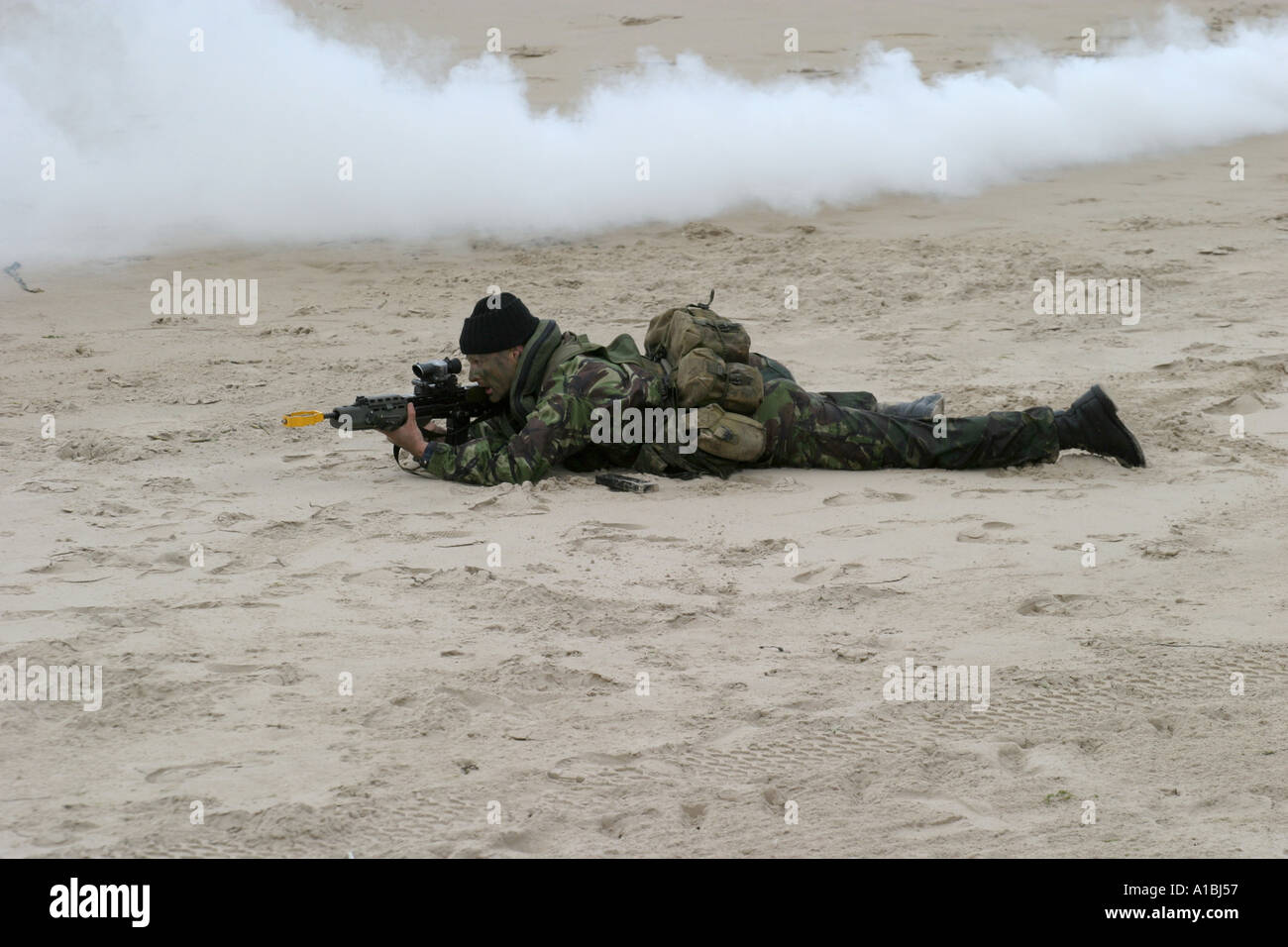 Royal Irish Regiment Soldaten nimmt Scharfschütze Position im Rauch während mock Strand Angriff Übung auf Portrush Strand West Strand Stockfoto