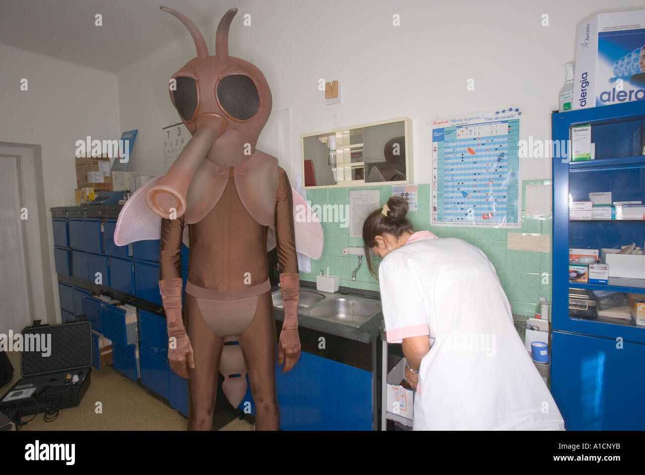 penisring überziehen Großer Mann in Mücke Kostüm tragen eine Sexpuppe in ein Büro, beobachtet  von einem Lady-Offizier Stockfotografie