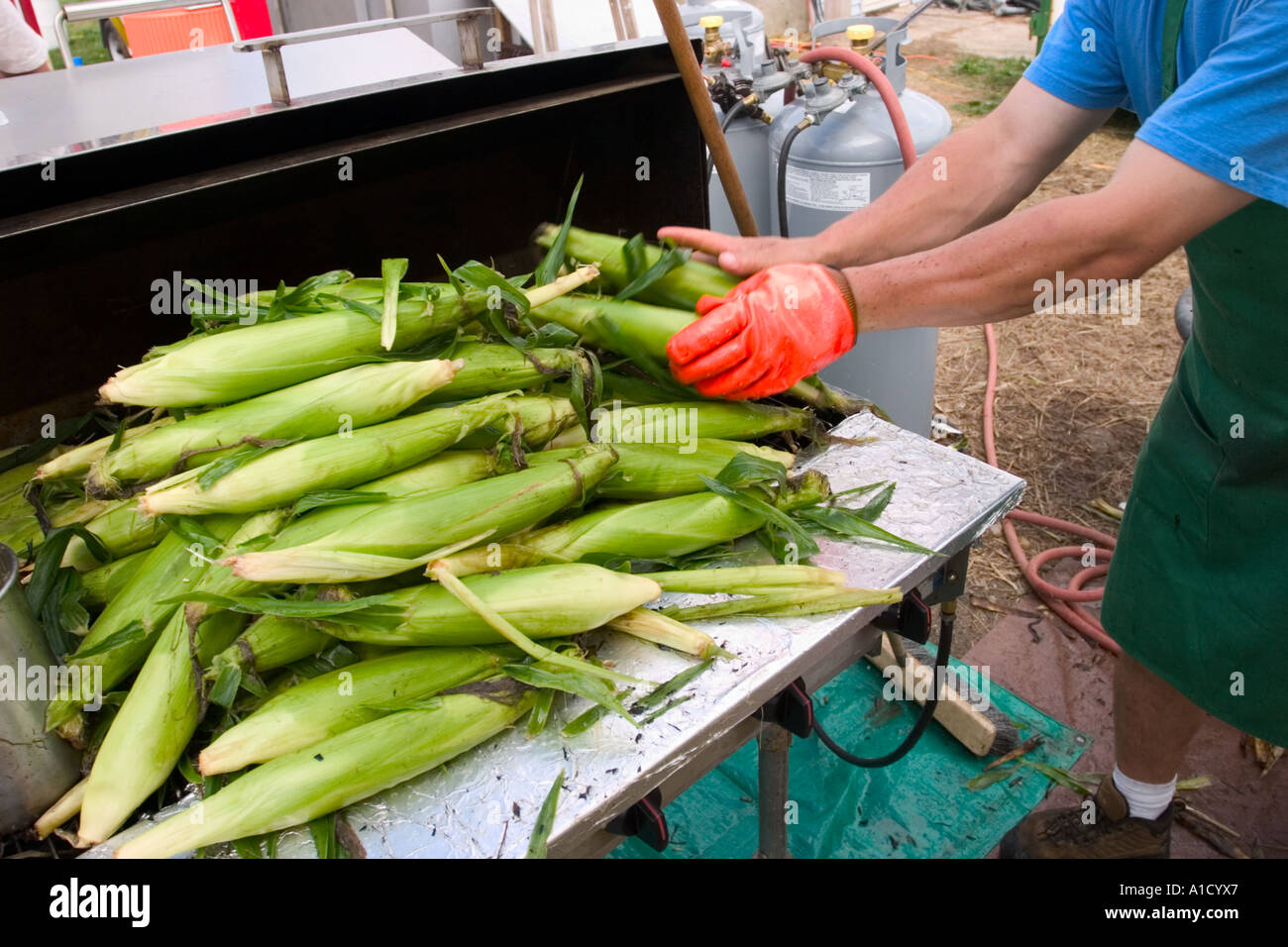 Männliche Verkäufer Mais zum Grillen auf einer Messe in Connecticut USA vorbereiten. Stockfoto