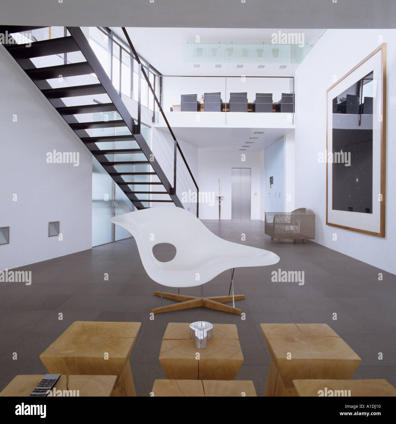 Eames Stuhl vor Philippe Starck Holzstühle in modernen Wohnung mit Zwischengeschoss Stockfoto