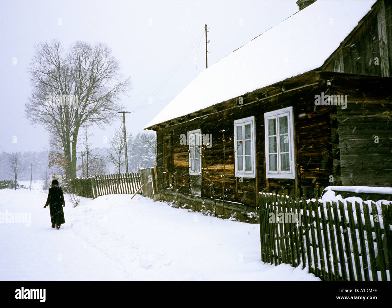 Polen Celiny verschneiten Straße Hütte und Lady walker Stockfoto