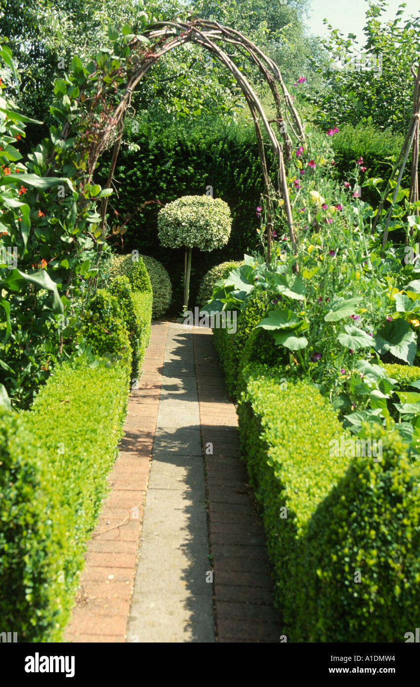 Weg durch die Küche Garten führt zu Hecke zwischen zugeschnittenen Buchsbaumhecken Stockfoto