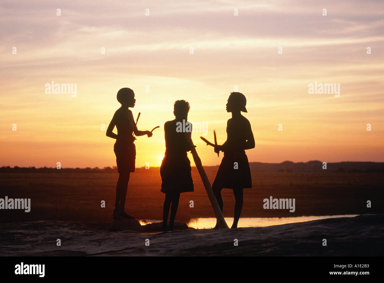 Aborigines Brüder Rowen Brian und Thomas Musizieren mit Didgeridoo und Clap-Sticks wie die Sonne untergeht auf Wulk Arnhem Land Stockfoto