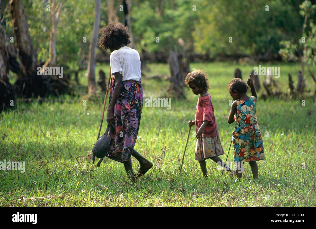 Aborigine-Frau Julie Djulibing mit Enkelkindern, die Schildkröte in eine leichte Sumpf in der Nähe von Mulgurram Arafura Arnhemland Jagd Stockfoto