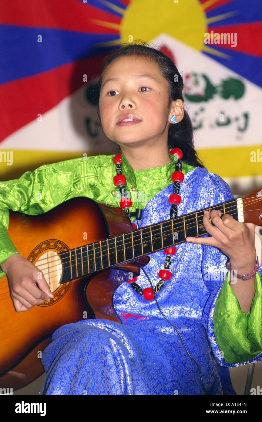 Junges Mädchen Sänger Interpret der tibetischen Kunst Musik vor Nationalflagge Tibets Stockfoto