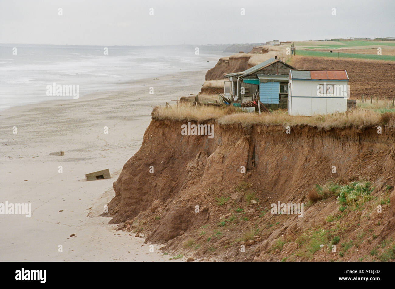 Häuser aufgegeben, da die Küste von Osten Großbritanniens allmählich erodiert ist.  Sie werden bald ins Meer fallen. Stockfoto