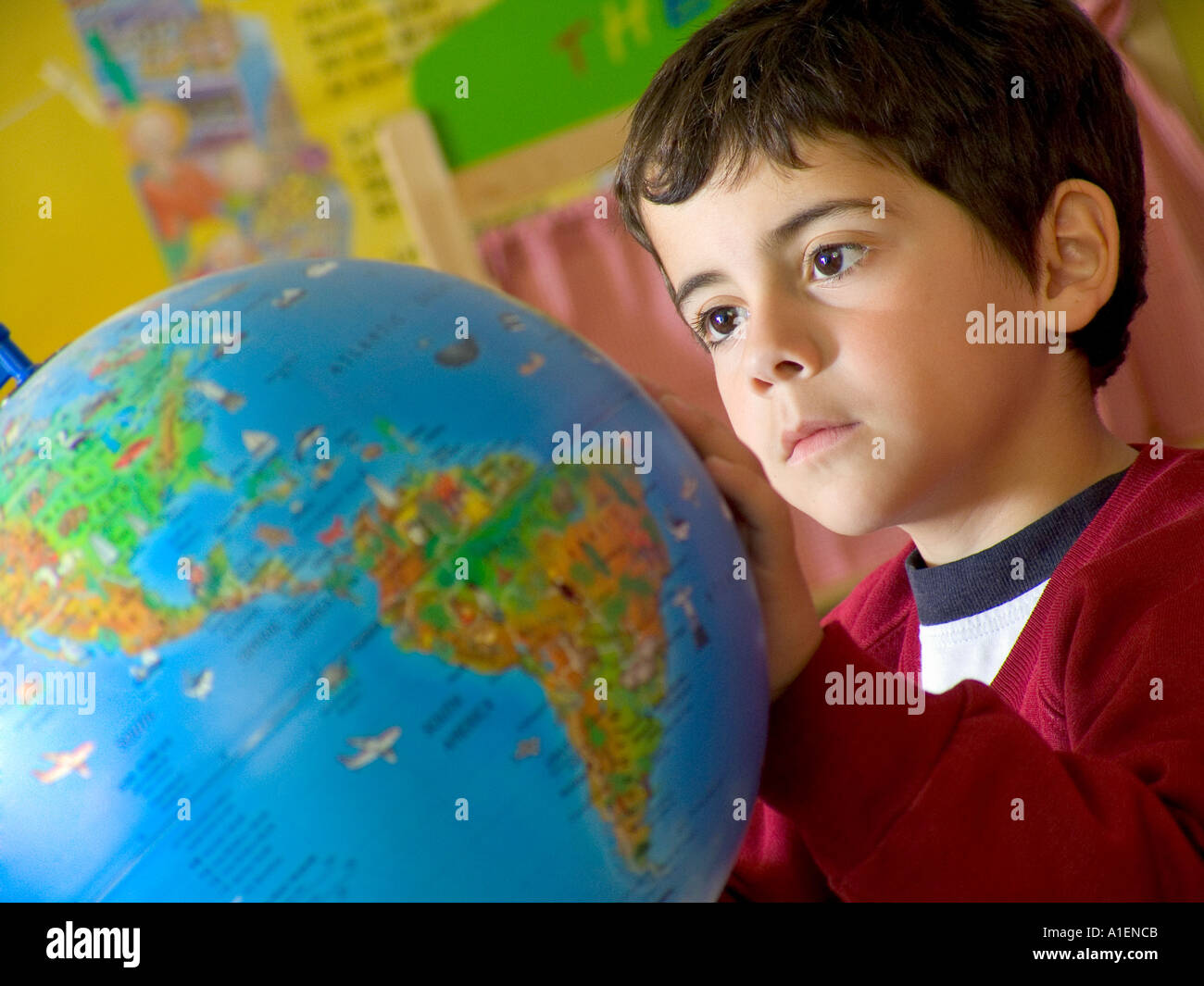 GLOBE Junior School Boy 5-7 Jahre Geographie Atlas Studie Nahaufnahme eines jungen Kleinkindes, der die Ozeane erkundet, Weltatlas, Globe Classroom Stockfoto