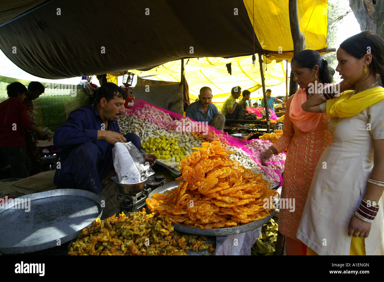 Frauen kaufen Süßigkeiten an Dussehra fair mit enormen Vielfalt an reiche indische Küche Mahlzeiten, Kullu, Indien Stockfoto