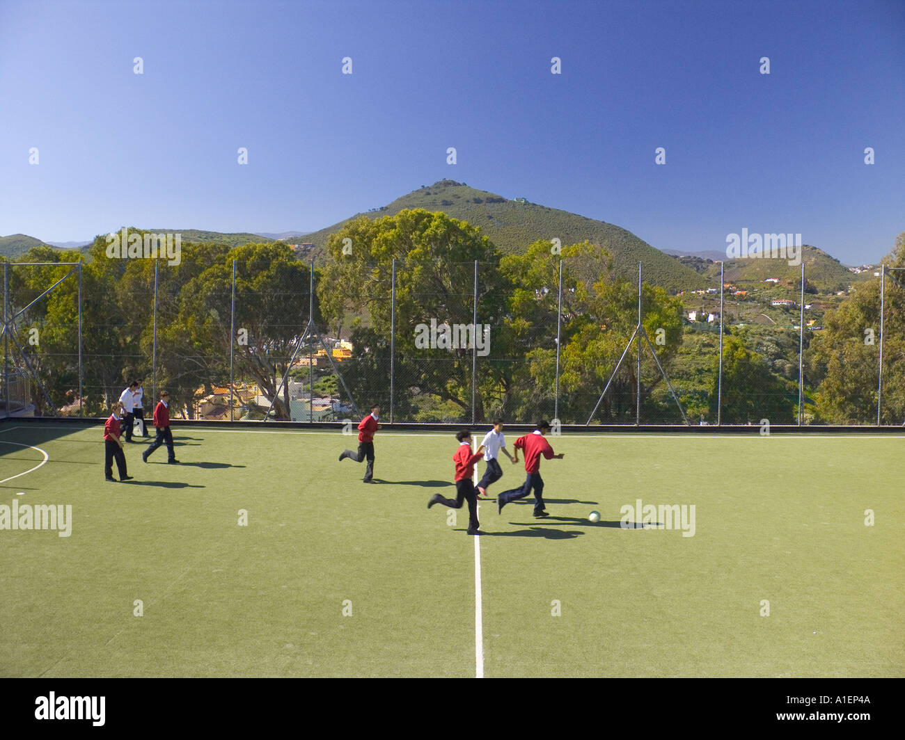 Schule Spielfeld sauber saubere Luft gesunde Umwelt Studenten Schüler Fußball auf Open air Sportplatz & Vista hinter im Sonnenlicht Stockfoto