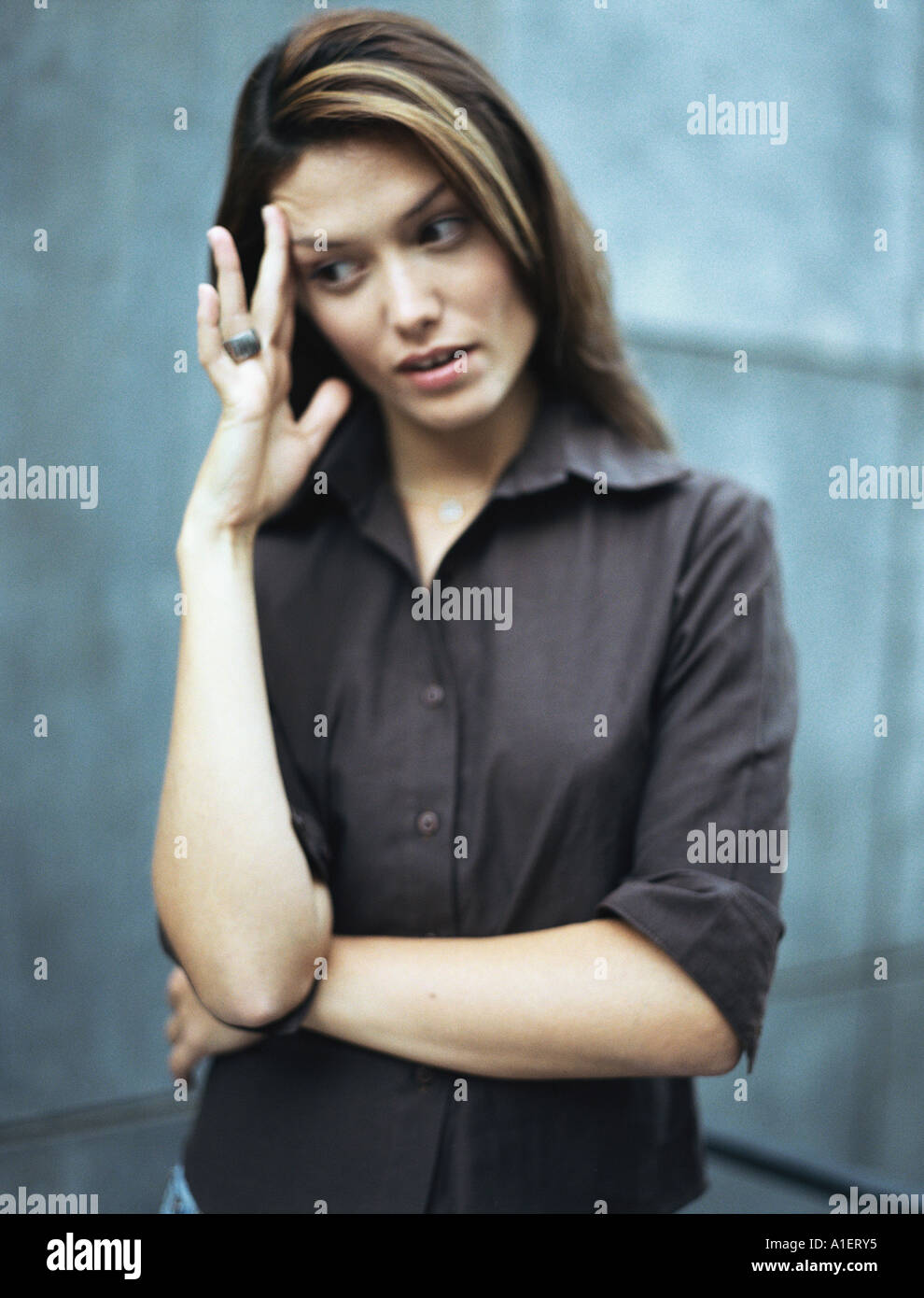 Frau stehend mit einem Arm über Körper, Kopf und wegsehen Stockfoto