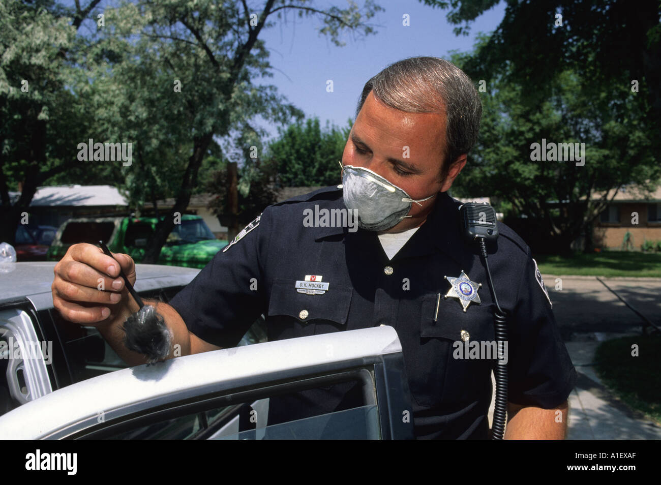 Ein Polizist Fingerabdrücke eine Auto Tür CSI Verbrechen Ermittler Beweise zu sammeln Stockfoto