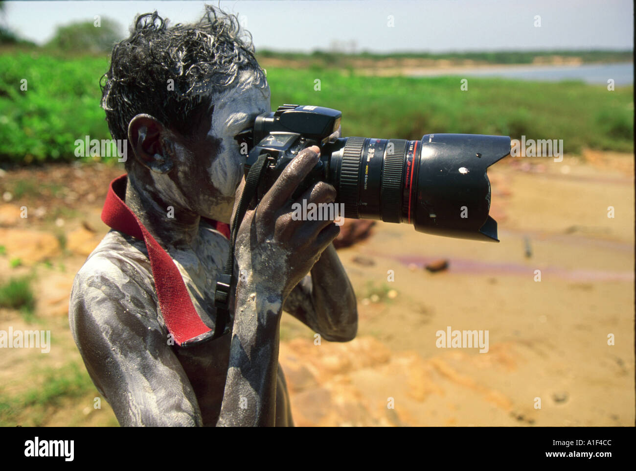 Aborigines junge malte Balandika mit weißer Tonerde macht meine Kamera an seine Kumpels im Arnhemland Galiwinku Insel Stockfoto