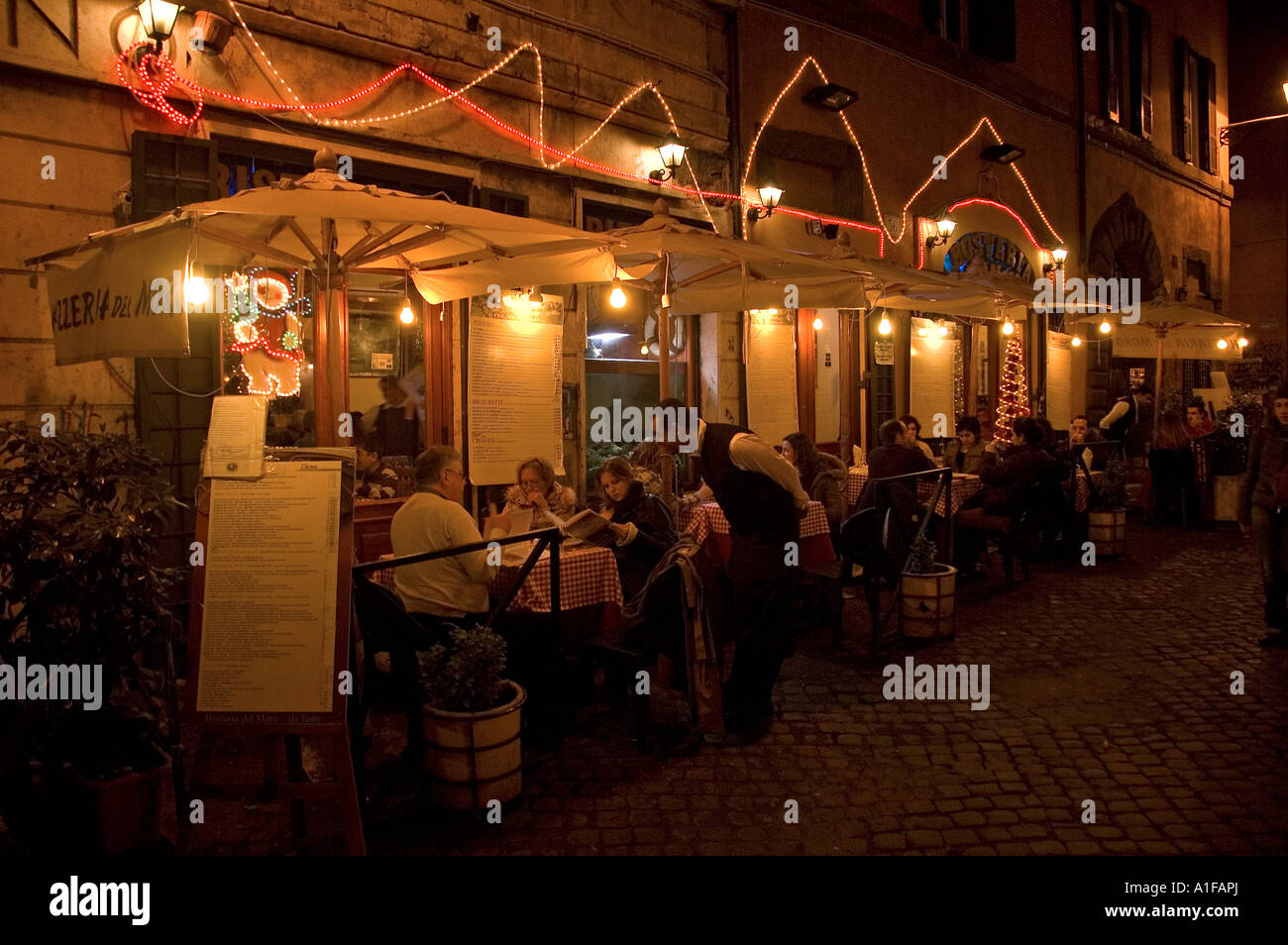 Gäste speisen vor einem Restaurant im Stadtteil Trastevere in Rom, Italien Stockfoto