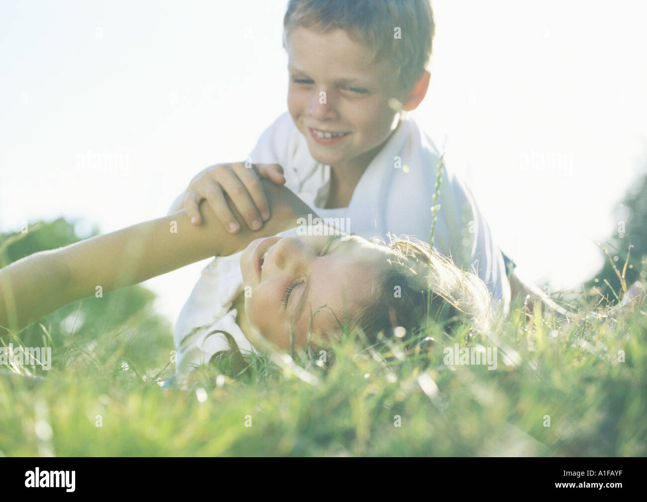 Jungen und Mädchen spielen in Rasen Stockfoto