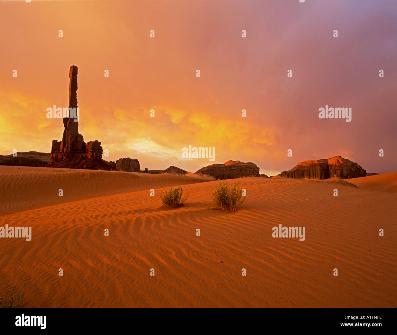Sonnenaufgang und Sanddünen mit Totem Pole Monument Valley in Arizona Stockfoto