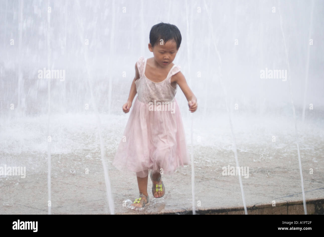 Chinesisches Mädchen läuft durch Brunnen in Renmin Völker Quadratmeter shanghai china Stockfoto
