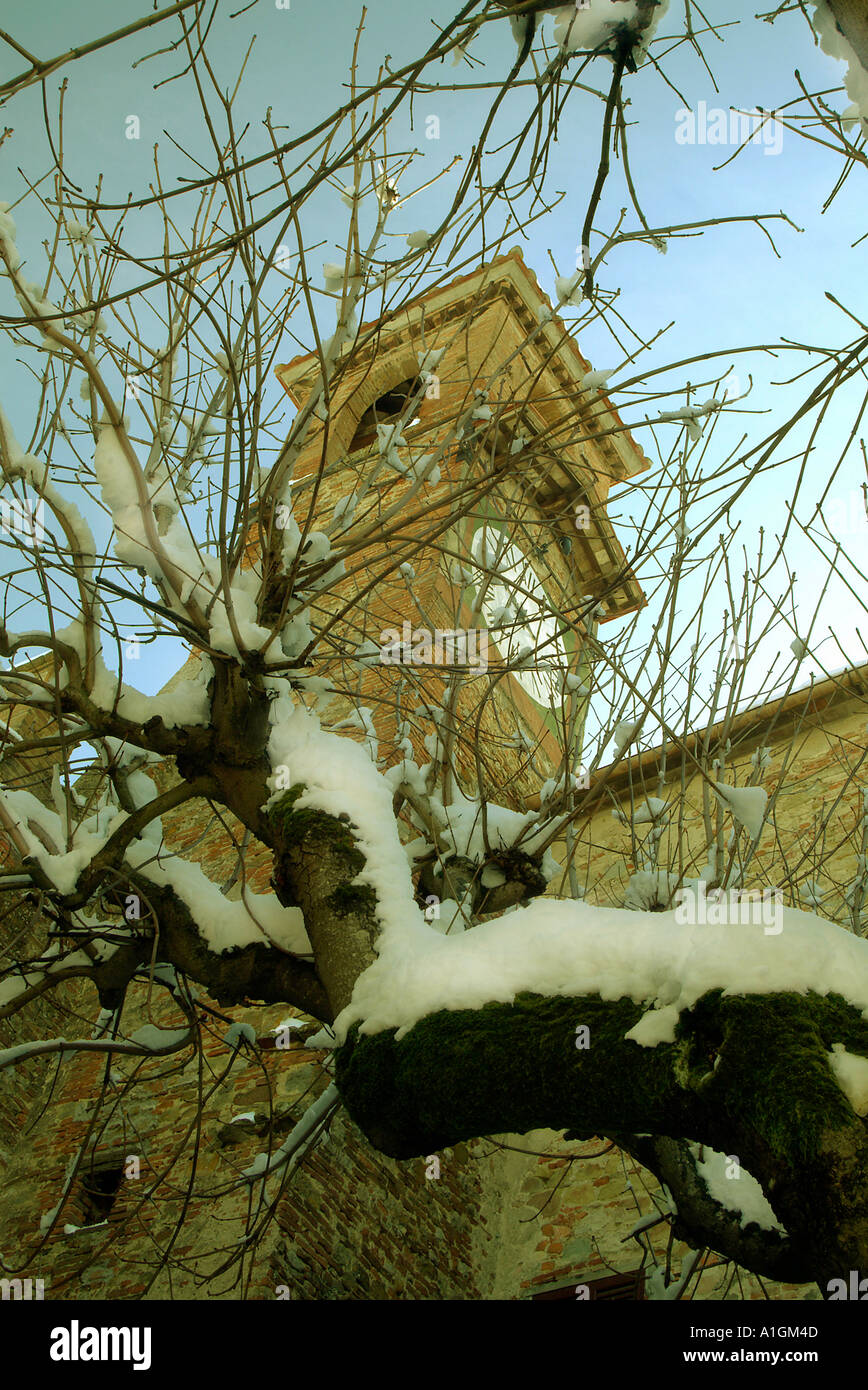 Eine Turmuhr wird vom Schnee bedeckten Zweige wie eine Metapher für das Ende des Lebens Umbrien Italien erfasst. Stockfoto