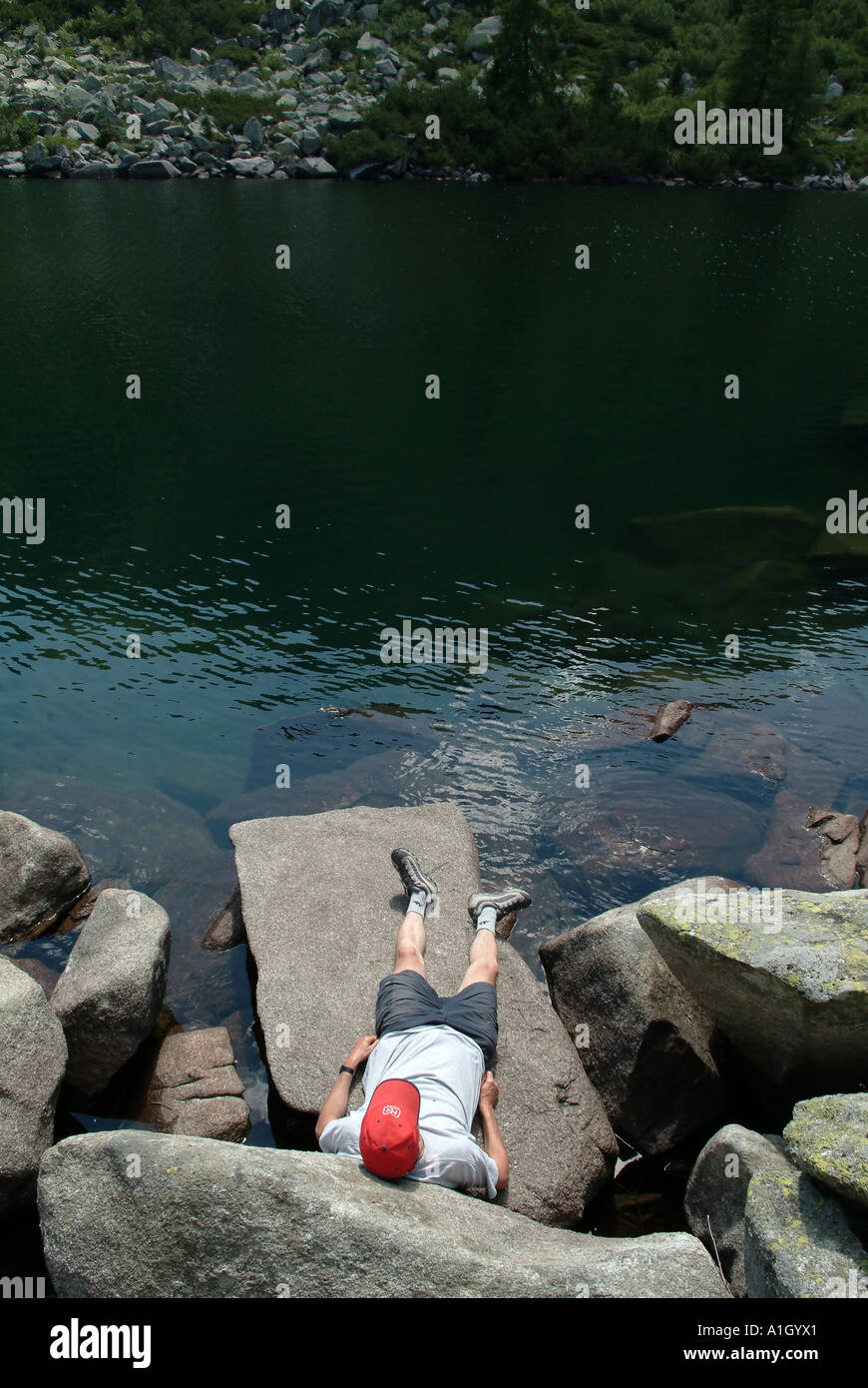 Mann hat eine erholsame Zeit am See an einem sonnigen Tag Stockfoto