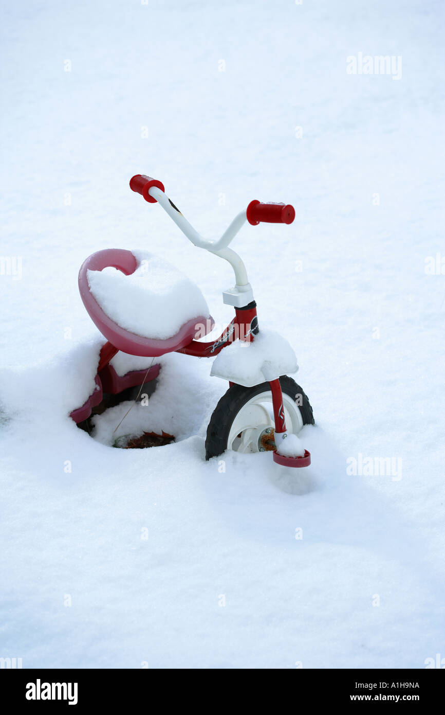 Des Kindes Dreirad mit Schnee bedeckt Stockfoto