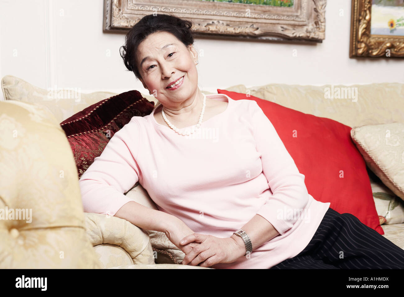 Porträt einer älteren Frau sitzen auf einer couch Stockfoto