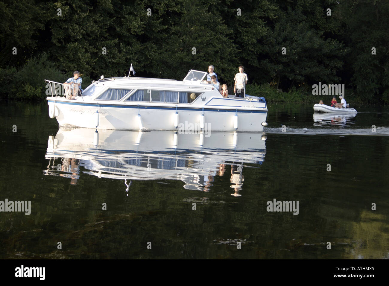 Fluss-Cruiser und kleinen schmuddeligen hinter an der Thames River Berkshire England Stockfoto