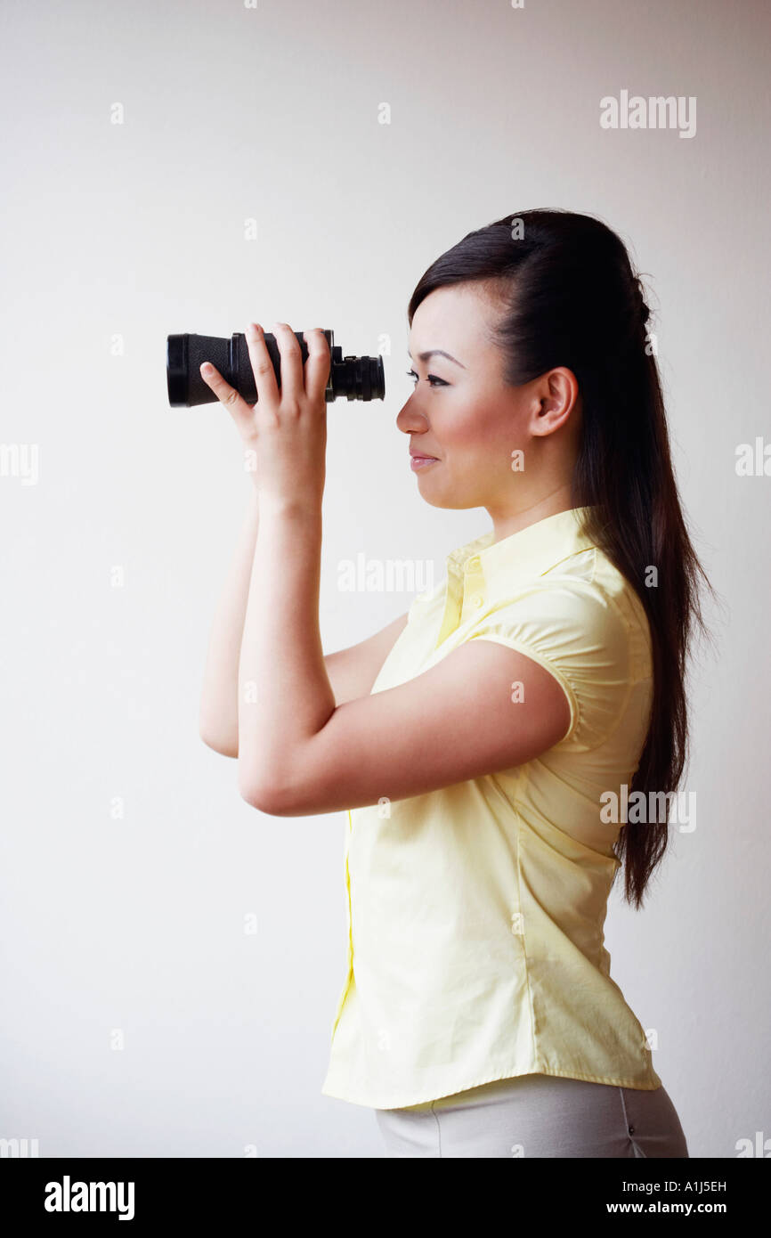 Seitenansicht einer Mitte erwachsenen Frau Blick durch ein Fernglas Stockfoto