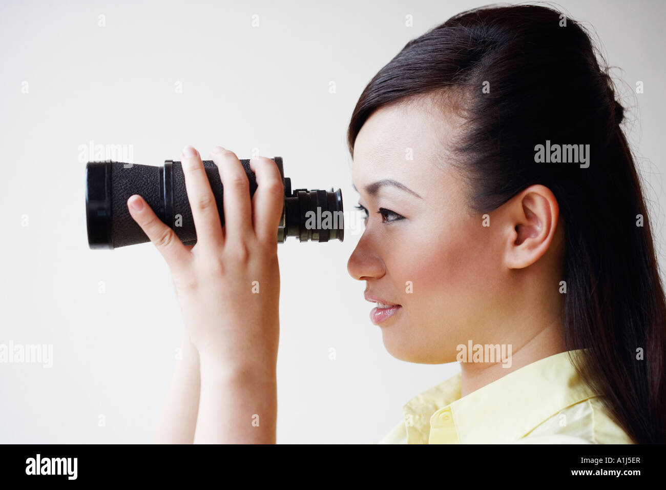 Seitenansicht einer Mitte erwachsenen Frau Blick durch ein Fernglas Stockfoto