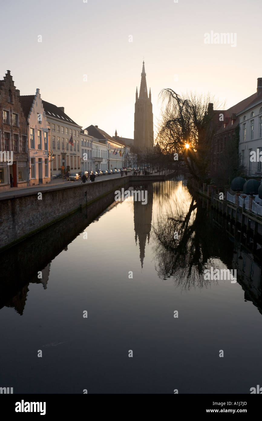 Blick auf den Kanal bei Sonnenuntergang mit Blick auf die Onze Lieve Vrouwekerk Brügge, Belgien Stockfoto