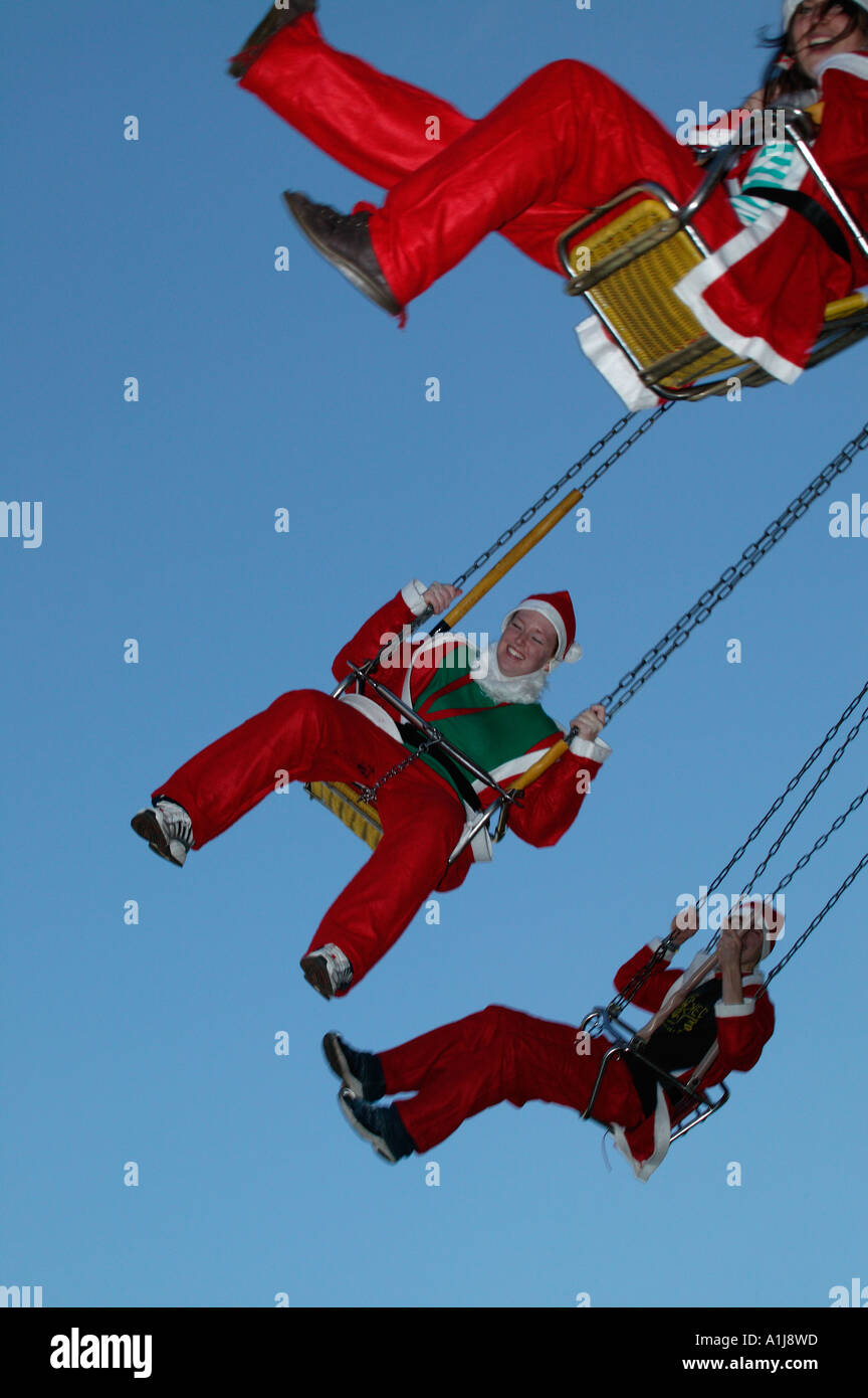 Menschen verkleidet Weihnachtsmann Outfits auf eine Jahrmarktsattraktion in Edinburgh, Schottland, UK, Europa, Kursvergleich Stockfoto