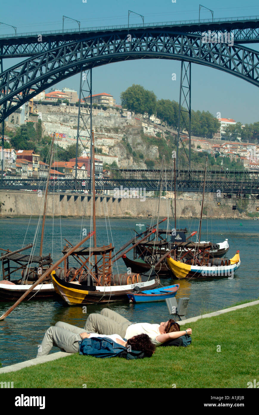 Touristen ruhen auf der Embankement mit dem Dom Luis Brücke im Hintergrund Porto Portugal Stockfoto