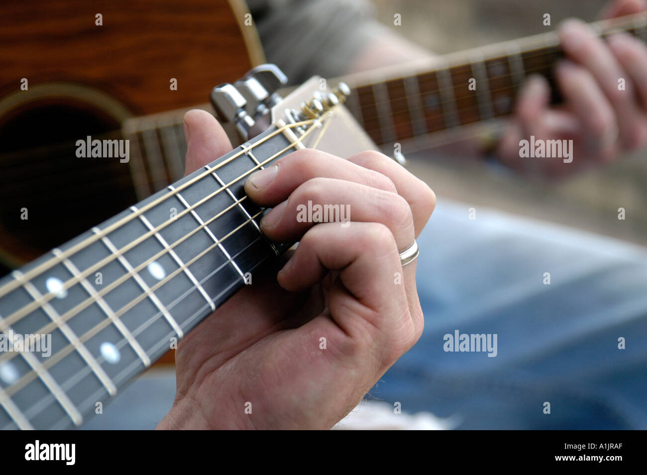 Nahaufnahme von beiden Caucasion Hände auf die Griffbretter Akustikgitarren Stockfoto