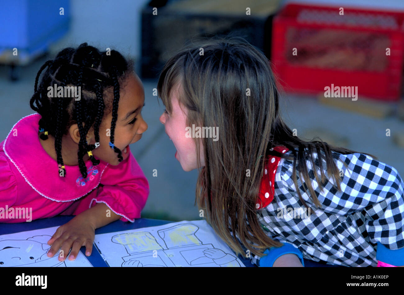 Zwei Mädchen Vorschule interagieren lachen, Nase an Nase. Stockfoto