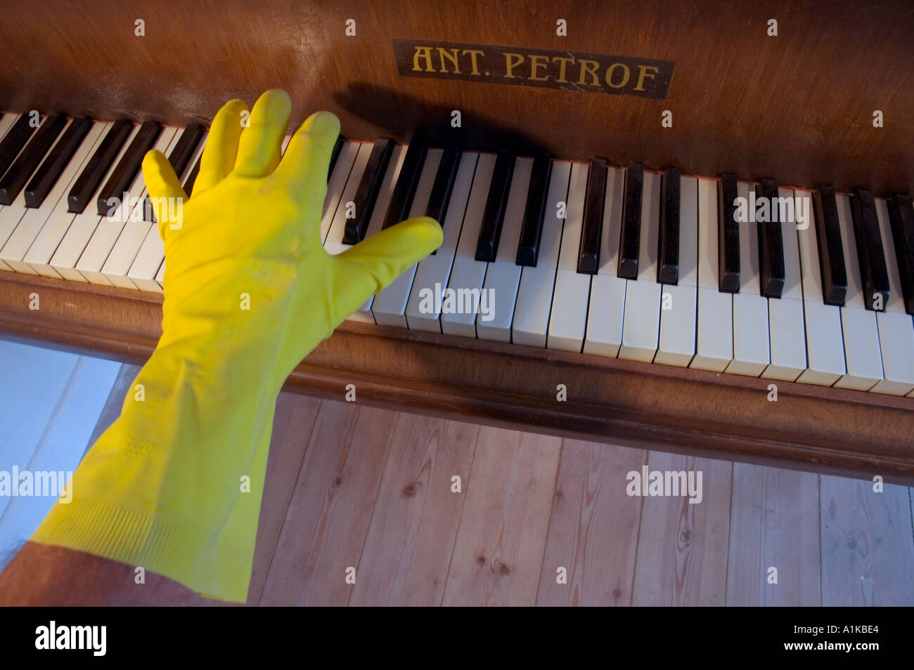 Mans linke Hand tragen gelbe Abwasch Handschuh mit dem Klavierspiel. Stockfoto