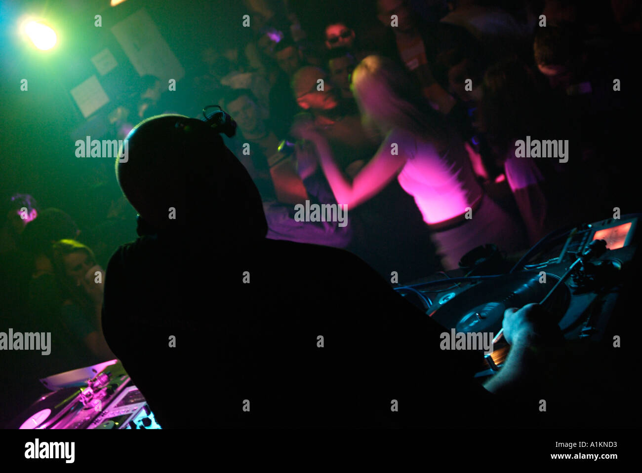 Club-DJ, Techno-Musik zu spielen, in einem überfüllten Nachtclub Stockfoto