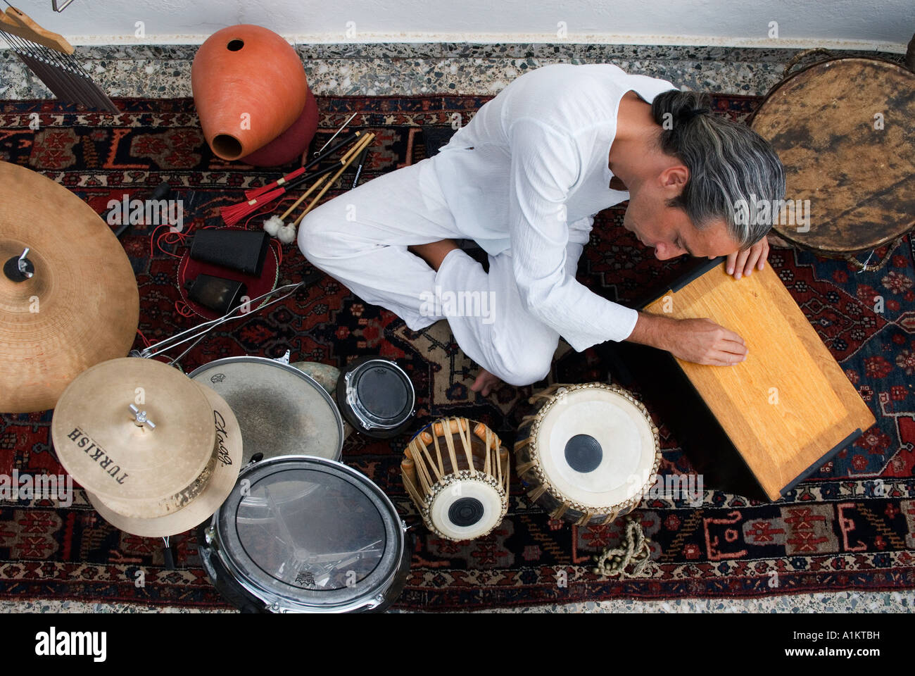 Musiker sitzt umgeben von seinem Percussion-Instrumente Stockfoto