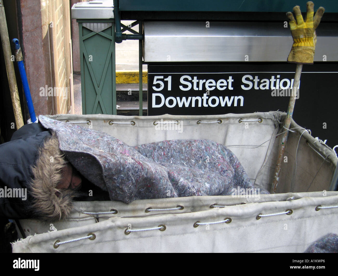 Obdachloser schläft in einem Korb außerhalb einer u-Bahnstation Manhattan NYC Stockfoto