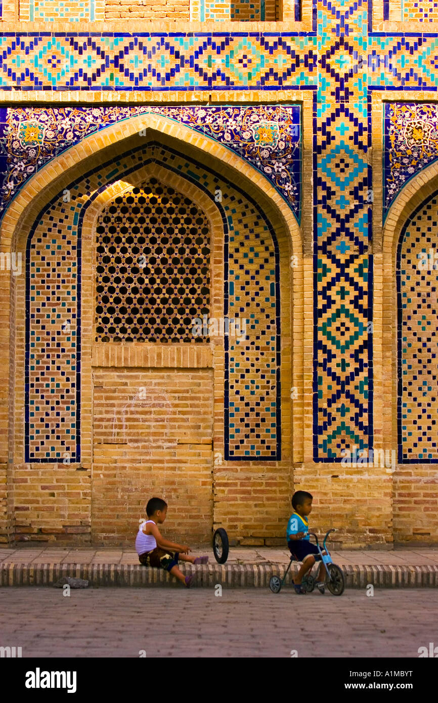 Kinder spielen vor einer Medrese, Buchara, Usbekistan Stockfoto