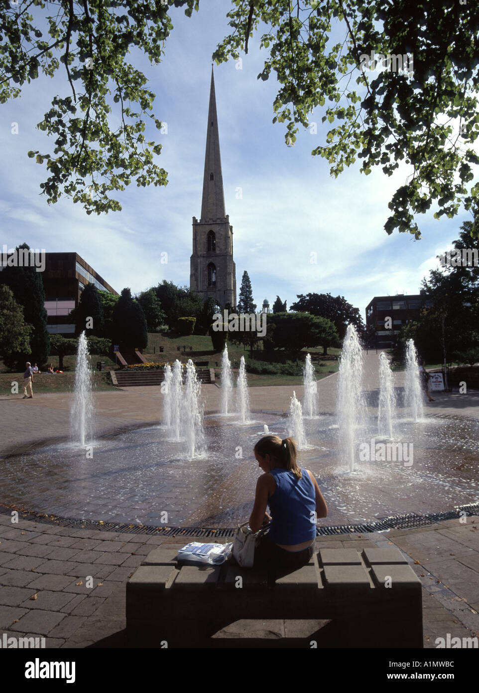 Worcester Brunnen inmitten gepflasterte Fläche mit den Resten der Turmspitze des Str. Andrews Kirche jenseits und junge Dame auf der Bank sitzen Stockfoto