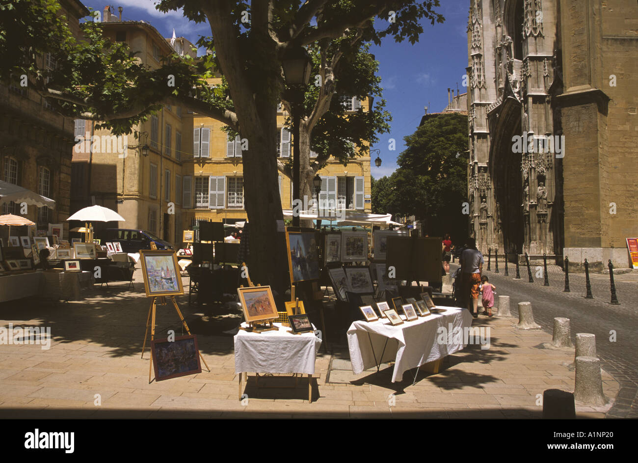 Gemälde zum Verkauf auf Leinen gedeckte Tische auf einem sonnigen Platz in Aix in Provence - A Street Szene Frankreich Stockfoto